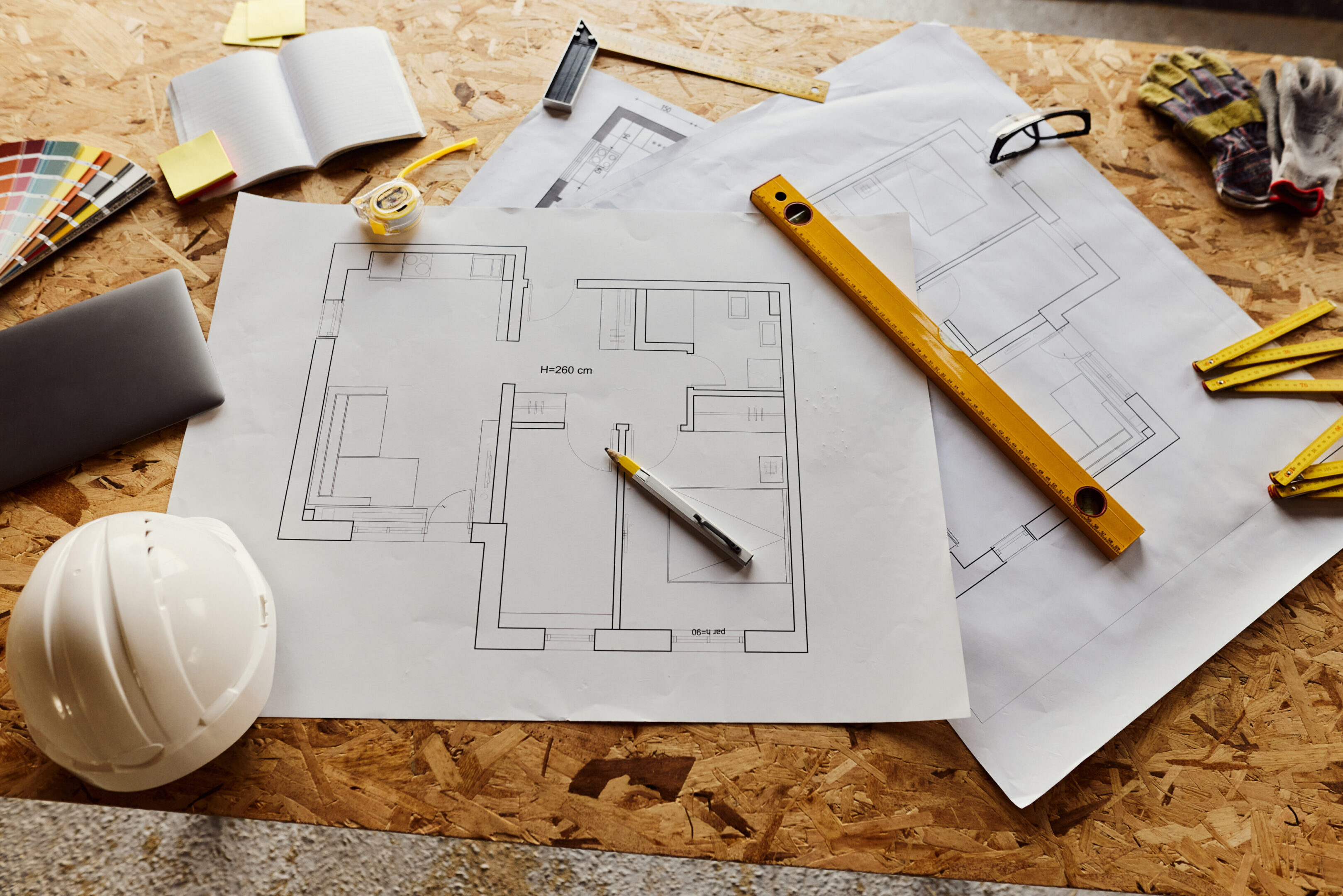 Above view of large group of work tool and blueprint at construction site.