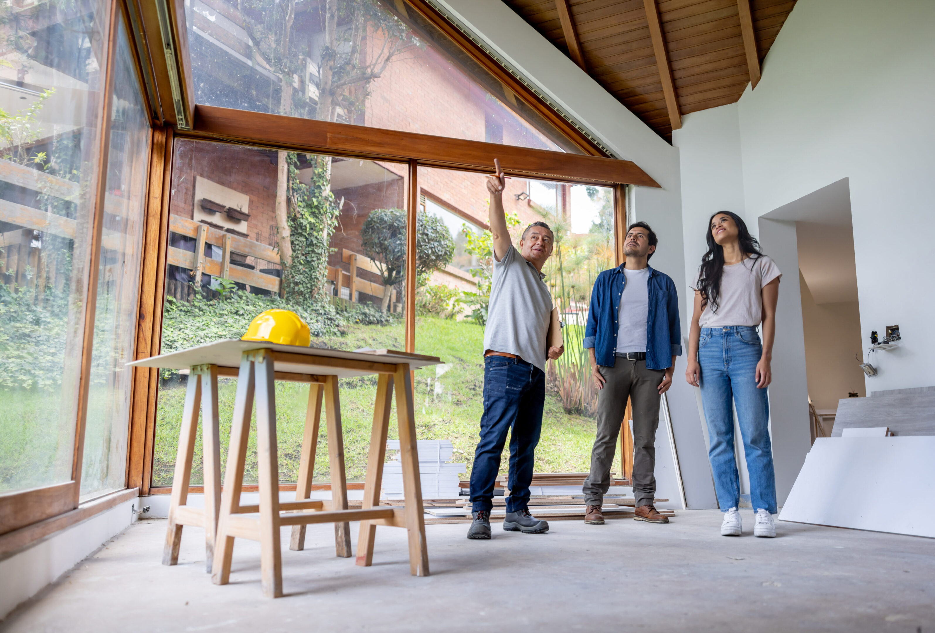 Latin American building contractor talking to clients renovating their house and sharing ideas